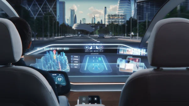 In-cabin view of an autonomous vehicle with a holographic windshield display showing navigation and vehicle status