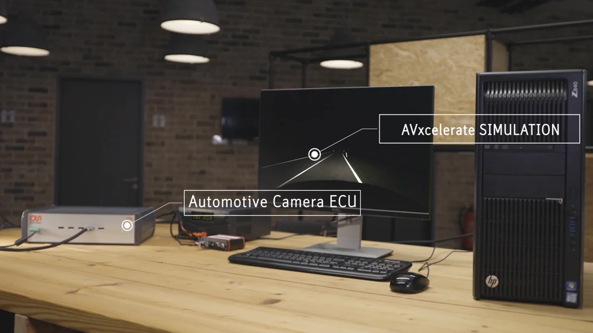 Hardware-in-the-loop bench: an automotive camera ECU connected to a workstation running an AVxcelerate simulation of a night road