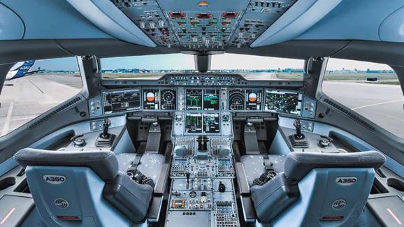 Interior of a modern airliner cockpit showing instrument panels and displays