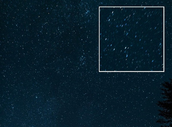 Night sky photograph with stars near the field edge stretched into comet shapes